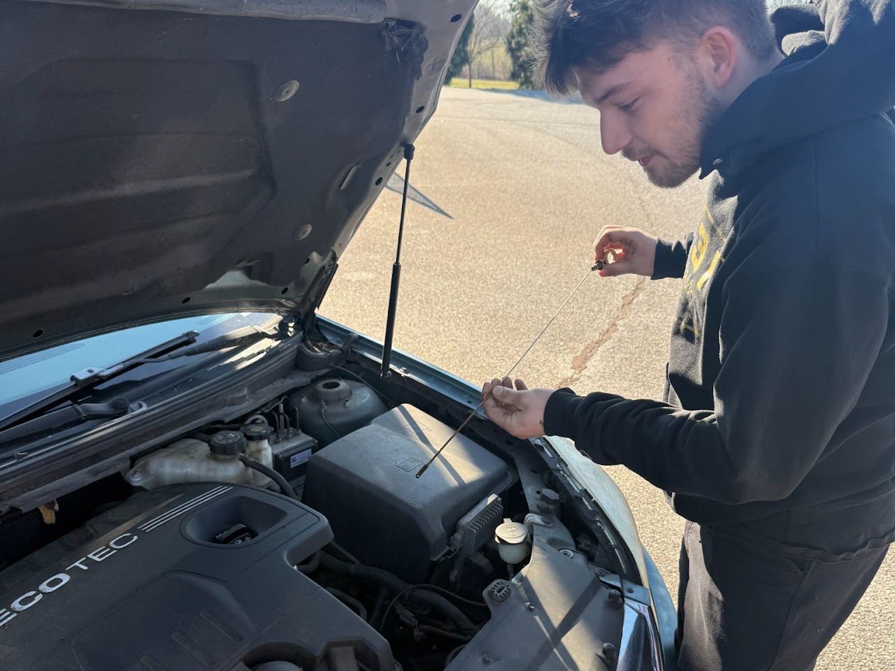 Tucker Bohannon, owner of Tucker's Mobile Mechanic, checking the oil on a customer's vehicle in Habersham, GA